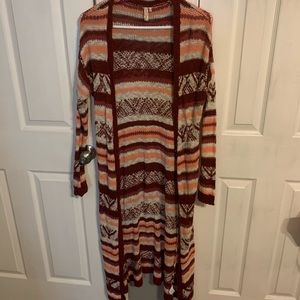 long stripped white, coral, and maroon sweater.